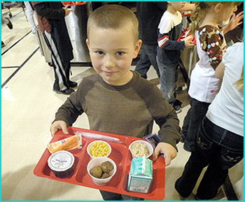 a picture of a boy holding a lunch tray